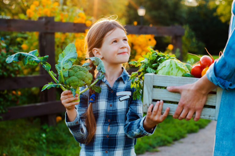 Petite fille dans un potager avec ses parents